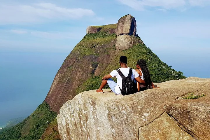 Paar sitzt am Klippenrand und genießt die Aussicht auf die Pedra Bonita