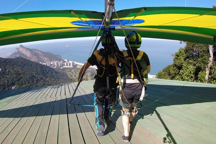 Zwei Personen stehen auf der Rampe und bereiten sich auf einen Tandem-Drachenflug vor